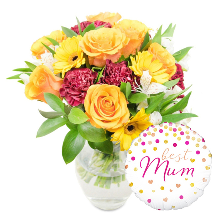 This vibrant bouquet, arranged with a florist's eye for balance and warmth, is presented against a pristine white backdrop so every hue is clear and inviting. The principal blooms are large orange roses-some with a peach wash-each petal spiralling outward with a soft, velvety texture that suggests garden freshness. Bright yellow gerberas punctuate the arrangement like cheerful sunbursts, their dark centres giving them a classic, optimistic look. Interspersed for depth are rich burgundy carnations, their tightly ruffled petals offering a plush, tactile contrast to the smoother rose faces. Slender white alstroemeria with subtle speckling drift through the bouquet, adding delicate, almost lace-like accents and a faint floral perfume. A generous mix of glossy green leaves and fine foliage fills and supports the arrangement, creating a lush backdrop that accentuates the warm palette. The flowers are placed in a clear glass vase where trimmed stems and fresh water are visible, a detail that highlights careful handling and recent preparation. Playfully positioned at the lower right, a round white foil balloon overlaps the vase slightly; it is decorated with scattered gold and hot-pink dots and tiny hearts, and bears a flowing fuchsia inscription reading best Mum, turning the whole piece into a personalised celebratory gift. The mood is joyful, affectionate, and refined-an ideal choice for Mother's Day, a birthday, or to express gratitude to a special mother in De Beauvoir Town, a short delivery route from Kingsland Road and the nearby towpath.