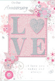 This image shows a romantic anniversary card, designed with the same care and balance a local florist might bring to an arrangement for a De Beauvoir Town celebration. At its heart is the word LOVE, formed in large, raised letters that stand proud from the card, their surfaces dusted with delicate glitter in tones of blush pink, creamy white, and hints of silver. The effect suggests soft sparkle rather than bold shine, like the gentle glimmer of petals under lamplight in a studio just off Kingsland Road. Encircling this central word is a refined pattern of stylised flowers and curling foliage, their shapes pared back yet expressive, as if quickly sketched while planning an anniversary bouquet. The blossoms, in shades of pastel pink and milky white with light grey and silver touches, drift across a pale pink background that feels smooth and velvety, lending the overall design a tranquil, intimate mood. Thin stems and swirling vines weave among the flowers, creating a sense of gentle motion, much like the loose, natural lines of a hand-tied arrangement. Tiny decorative flecks and curlicues nestle in the spaces between petals, adding visual interest without clutter. An elegant, scripted message in soft grey ink nestles near the base of the design, speaking of shared love, commitment, and cherished time together. The composition suggests a card placed beside a vase of fresh anniversary flowers in a De Beauvoir home, a quiet, heartfelt token that honours years of partnership and the beauty of everyday romance.